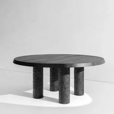 a black and white photo of a table with three columns on it's base