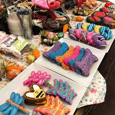 many decorated cookies are on the table with other items in front of them for sale