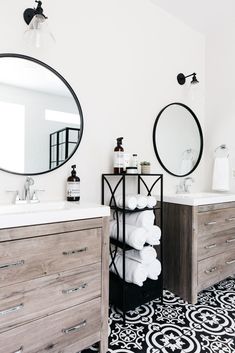 a bathroom with two sinks, mirrors and towels