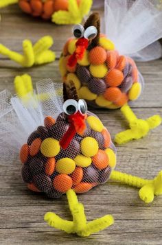 two turkeys made out of candy sitting on top of a wooden table