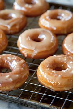 several glazed donuts on a cooling rack