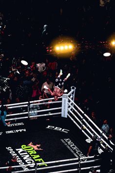 an overhead view of a boxing ring with people in the stands and onlookers