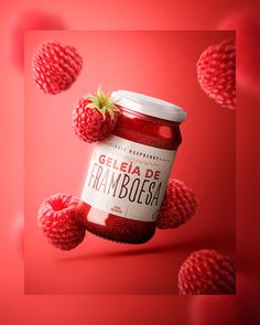 a jar of jam with raspberries floating around it on a red background, surrounded by smaller raspberries