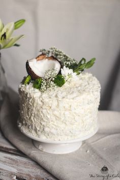 a white cake topped with coconuts and baby's breath on top of a table