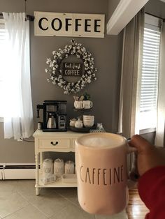 a person holding up a coffee mug in front of a door with the word coffee on it