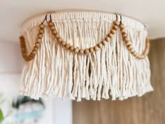 a white chandelier with wooden beads hanging from the ceiling