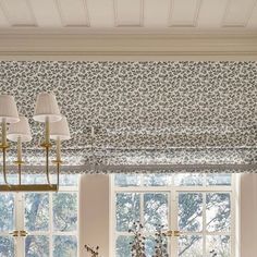 a living room filled with lots of furniture next to a window covered in floral curtains