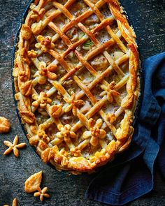 an apple pie with latticed crust on top and some nuts scattered around the edges