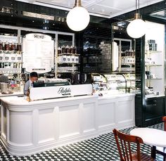 the interior of a restaurant with checkered floor and black and white tiles on the walls