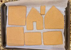 some cut out houses are sitting on a baking sheet and ready to be put in the oven