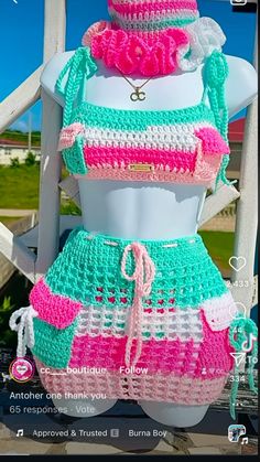 a mannequin wearing a crochet outfit with pink and green trims