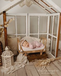 a baby is laying on top of a bed in a room with white walls and wood flooring