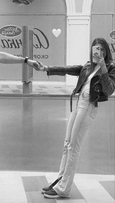 a woman is taking a selfie in front of coca - cola signs with her cell phone