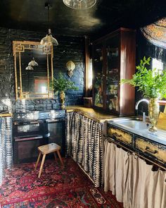 an old fashioned kitchen is decorated in black and white colors with gold trimmings