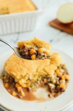 a piece of pie on a plate with a fork in it and another dish behind it