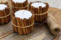 cinnamon stick candle holders on a wooden table with twine and burlock around them