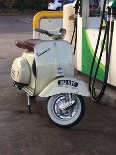 a scooter is parked next to a gas pump