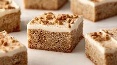 several pieces of cake with white frosting and nuts on top