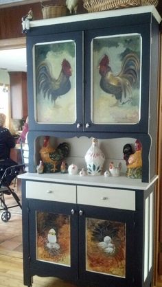 an old china cabinet with roosters painted on the doors