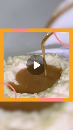 a bowl filled with mashed potatoes and gravy being drizzled on top