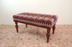 a wooden bench sitting on top of a rug