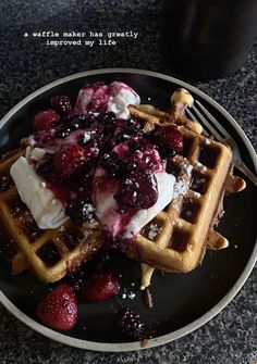 waffles topped with whipped cream and berries on a plate