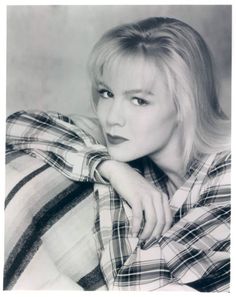 black and white photograph of a woman in plaid shirt with her hand on her shoulder