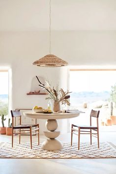 a dining room table with chairs and a basket hanging from it's centerpiece