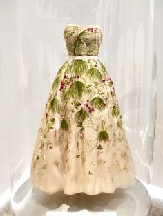 a white dress with flowers on it in a glass case at the national museum of women's history