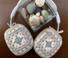 two crocheted pot holders with seashells in them