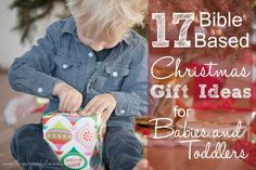 a little boy sitting on the floor opening a christmas gift box with text overlay that reads, 17 bible based christmas gift ideas for babies and toddlers