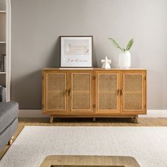 a living room with a gray couch and wooden cabinet