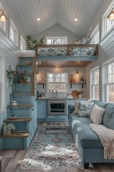 a living room filled with furniture next to a kitchen and lofted bed in a house