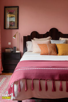 Pink bedroom featuring a dark wooden headboard, sleek black nightstand, geometric pillows, and a bold pink fringed throw. Elegant Pink Bedroom, Soft Pink Walls, Dark Wood Furniture, Brown Bed, Peaceful Home