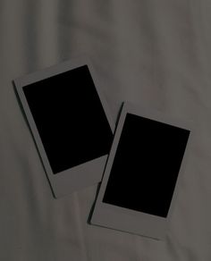 two black and white polaroid frames laying on a bed