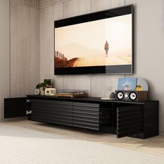 a flat screen tv mounted to the side of a wall above a black entertainment center