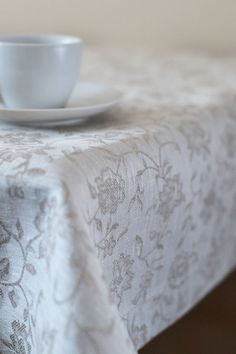 a white cup and saucer sitting on top of a table