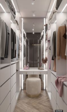 a walk - in closet with white cabinets, drawers and clothes hanging on the walls