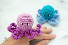 two crocheted octopus toys sitting next to each other on top of a table