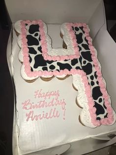 a birthday cake with the letter h on it's side in a cardboard box