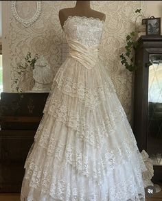 a white wedding dress on display in front of a mirror