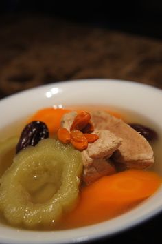 a white bowl filled with meat and vegetables