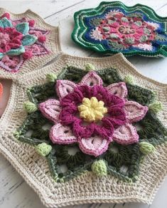 three crocheted flower coasters sitting on top of a table