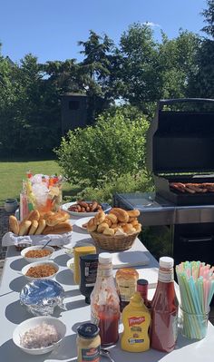 an outdoor bbq grill with food and drinks on the table in front of it