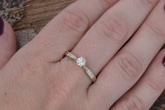 a woman's hand with a diamond ring on top of her finger and two other hands