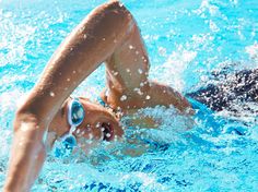 a woman swimming in a pool wearing goggles