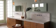 a bathroom with blue walls and white counter tops, along with two large mirrors on the wall