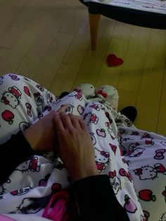 a person laying on the floor with hello kitty pajamas