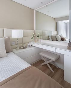 a bedroom with a bed, desk and mirror on the wall next to each other