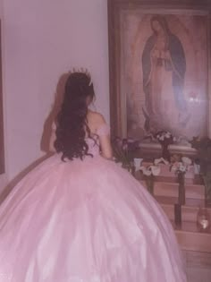 a woman in a pink ball gown is looking at the painting on the wall behind her